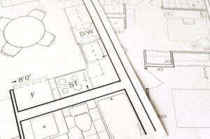 Close-up view of an architectural floor plan on paper showcasing detailed room layouts and measurements.